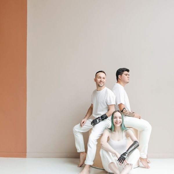 A diverse group of people of different ages sitting together in a bright studio.